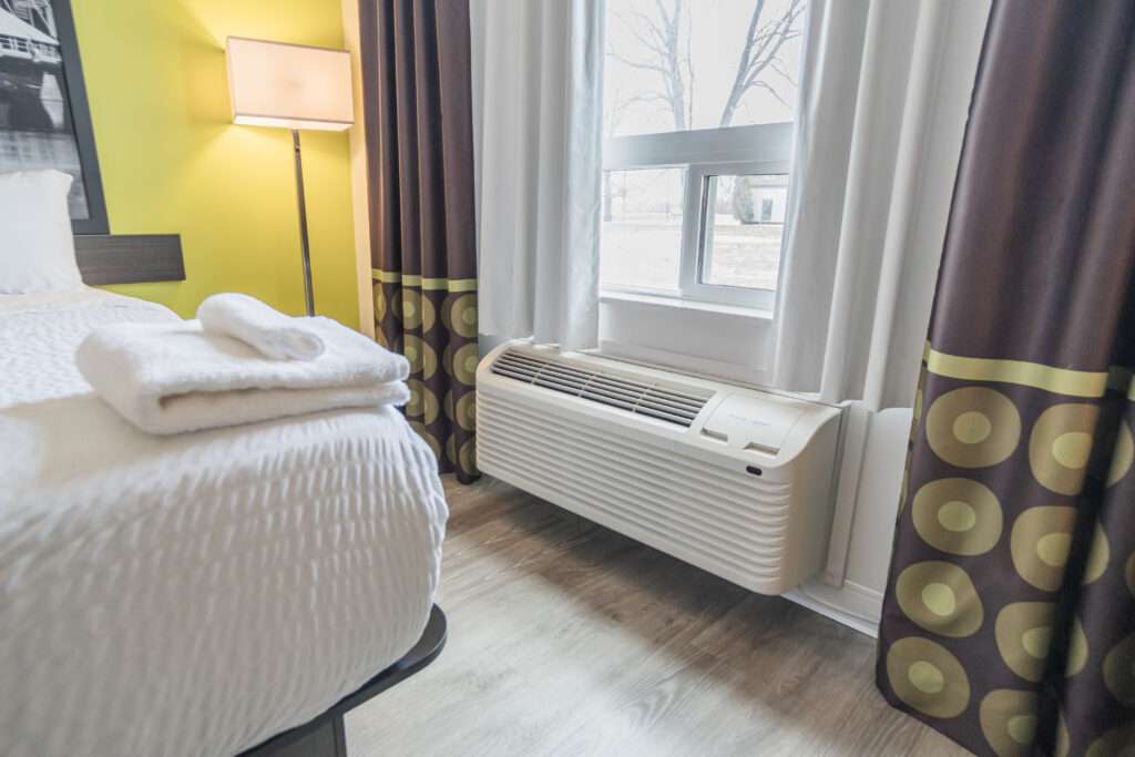 A bedroom with a bed and window in it. Canadian hotel room